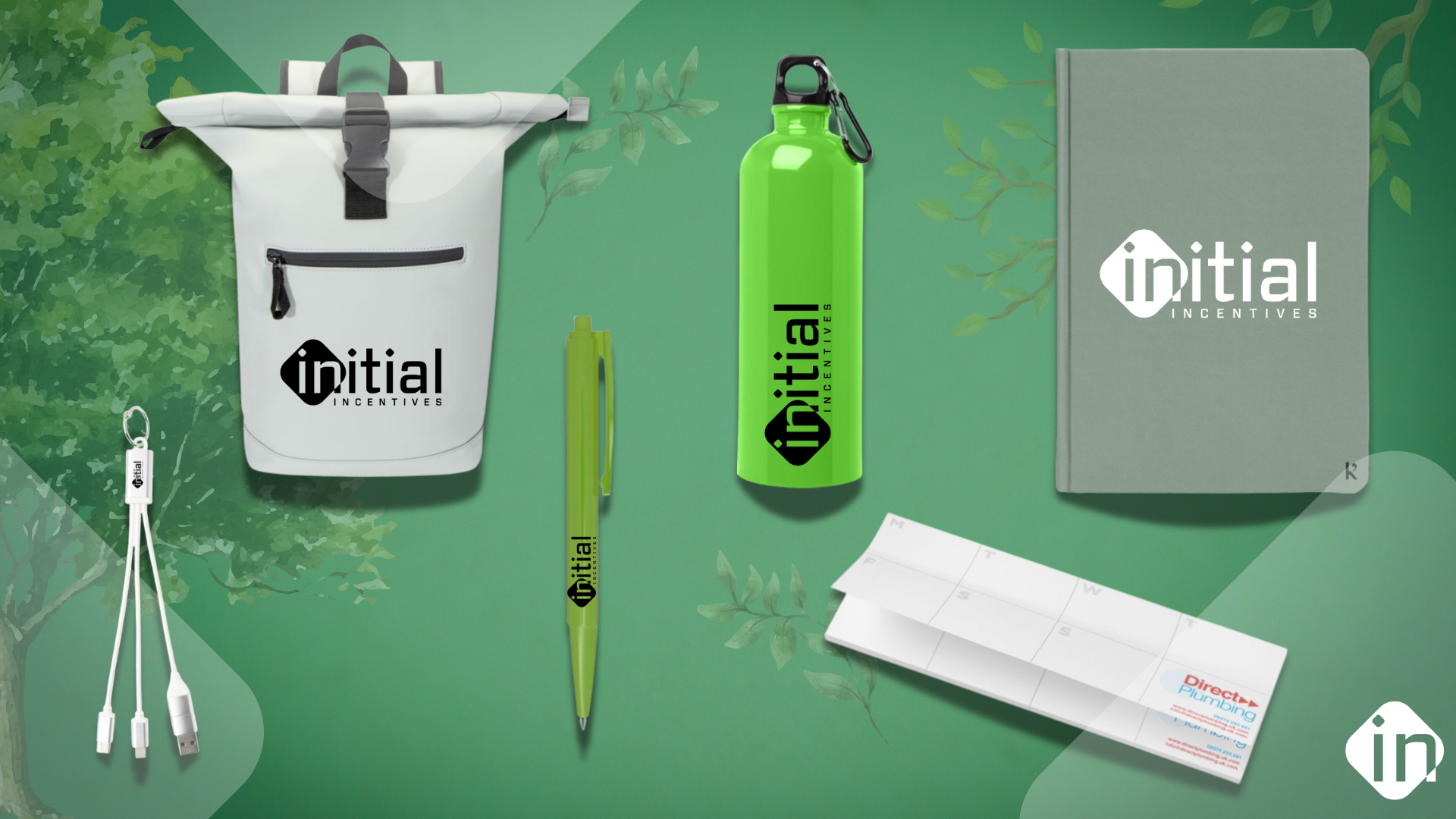 Custom branded merchandise including a backpack, water bottle, notebook, pen, charging cable, and desk calendar with company logo.