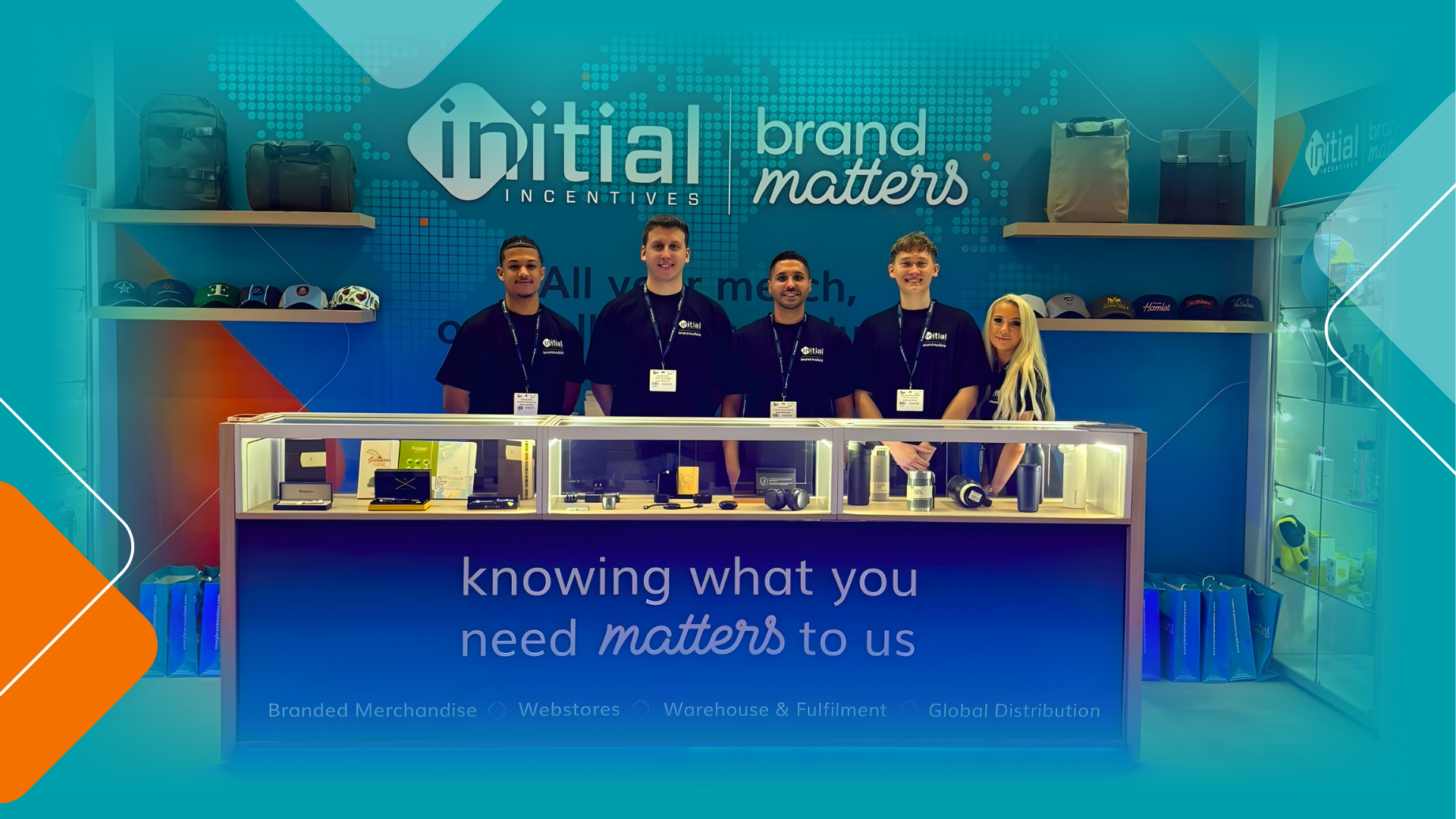 Initial Incentives and Brand Matters team standing at a branded exhibition stand showcasing merchandise, webstores, warehousing and global distribution services.